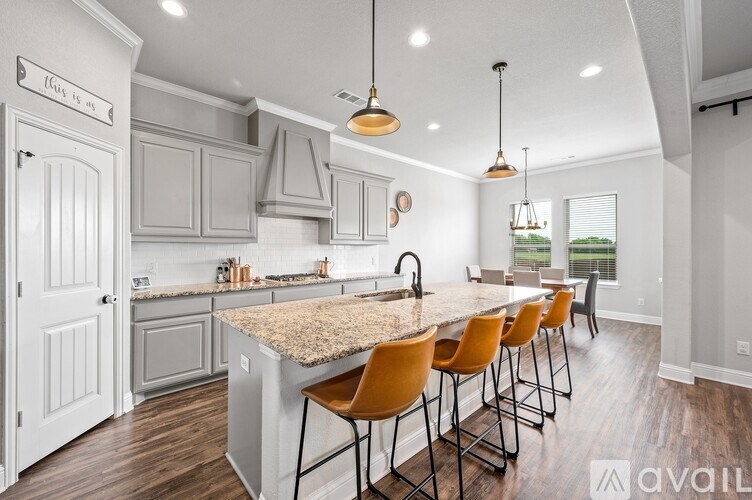A kitchen with a granite countertop and wooden floors.