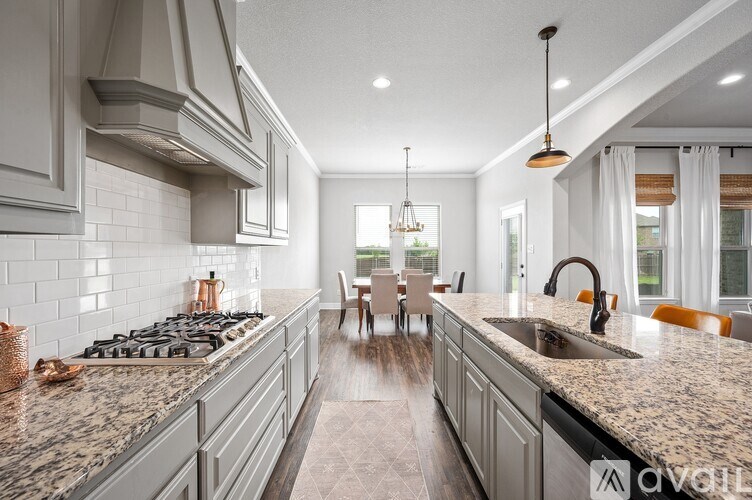 A modern kitchen with granite countertops and stainless steel appliances.