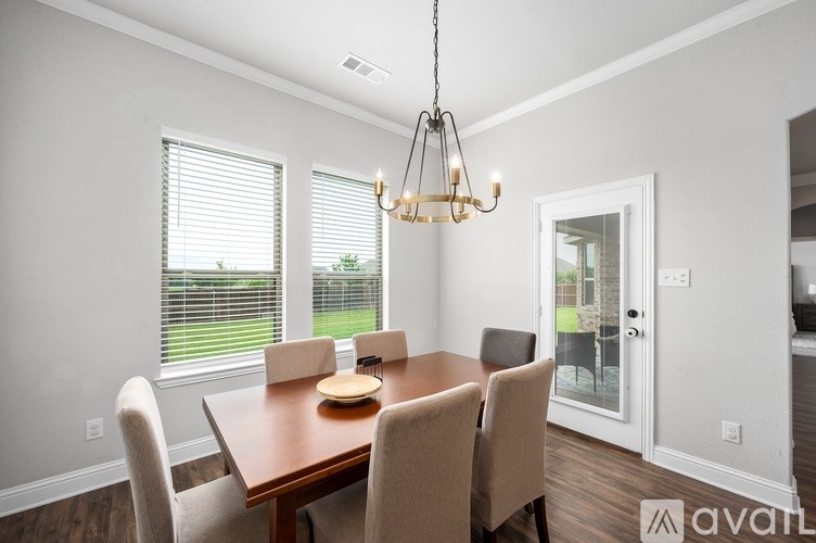 A dining room with a wooden table and chairs.