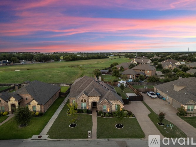 A suburban neighborhood with houses and a driveway leading to a large home.