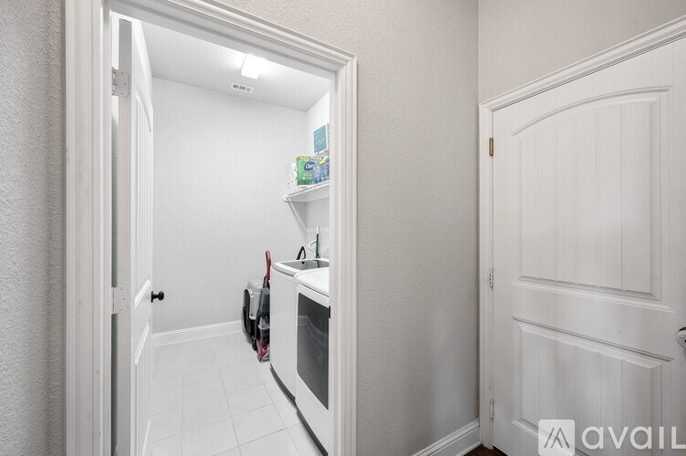 A white kitchen with a microwave and a fridge.