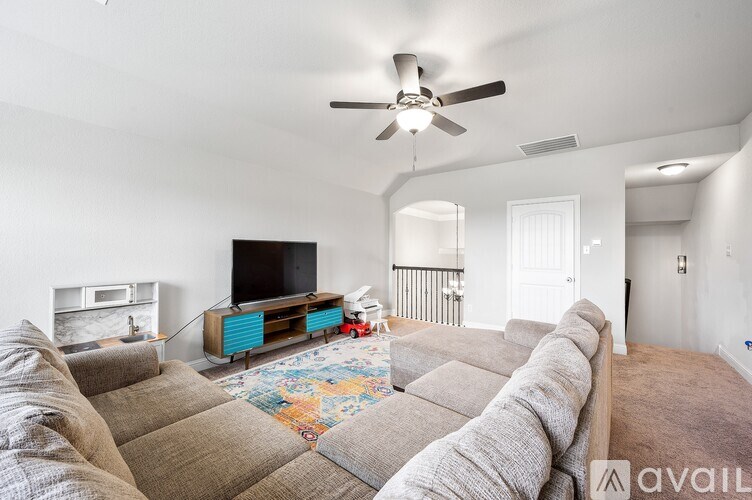 A living room with a grey sofa and a television.