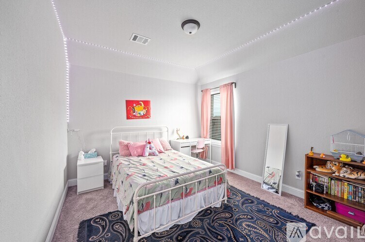 A bedroom with a bed, a dresser, a mirror, and a rug.