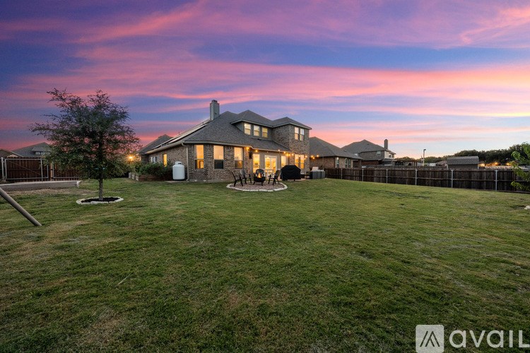 A house with a large lawn and a tree in front of it.