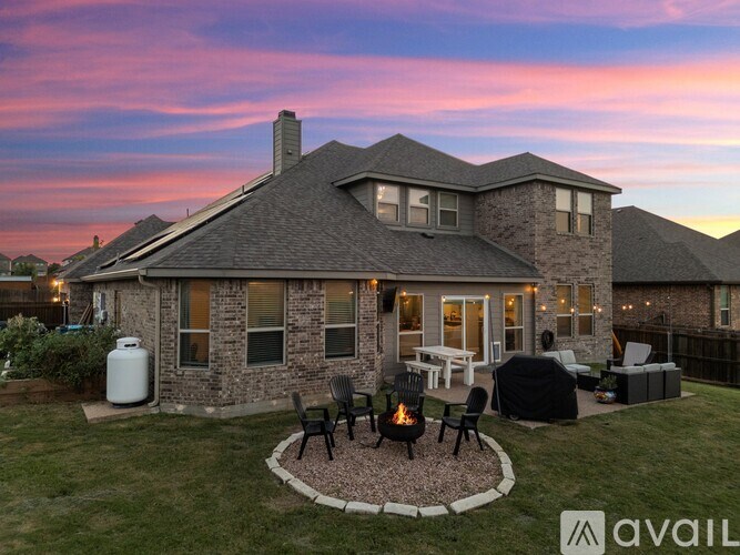 A house with a patio and a fire pit in the backyard.