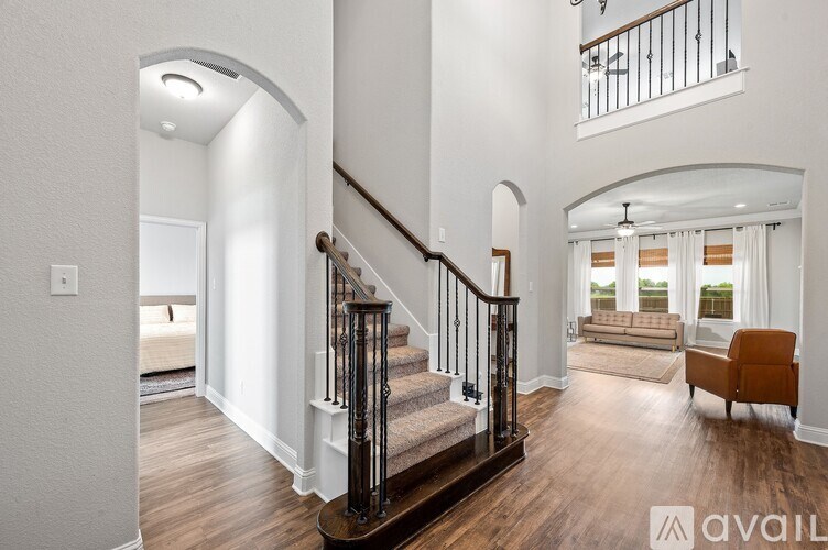 A spacious living room with a staircase leading to the upper floor.