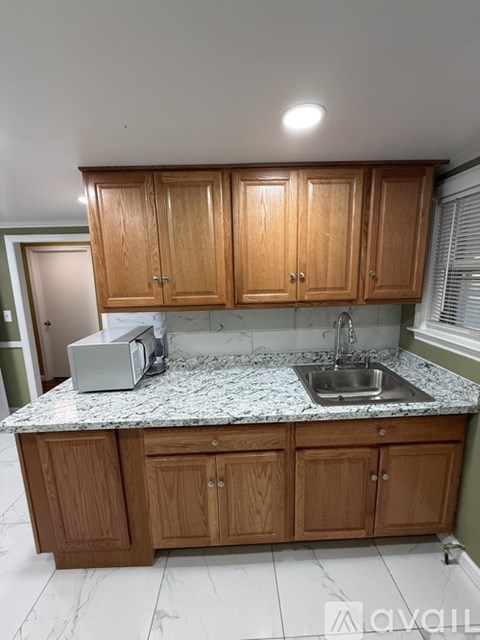 A kitchen with wooden cabinets and a granite countertop.