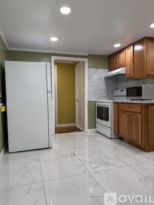 A kitchen with a white fridge and wooden cabinets.