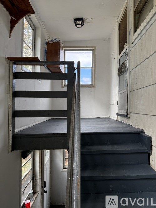 A staircase with a metal railing and a window on the side.