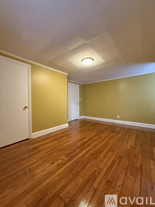 A room with wooden flooring and a white door.