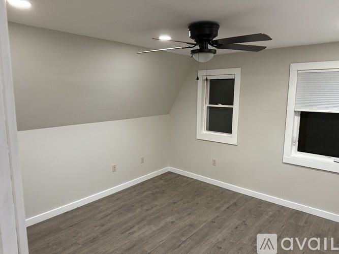 A room with a ceiling fan and a window.