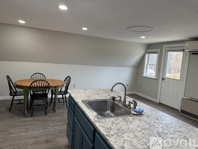 A kitchen with a table and chairs.