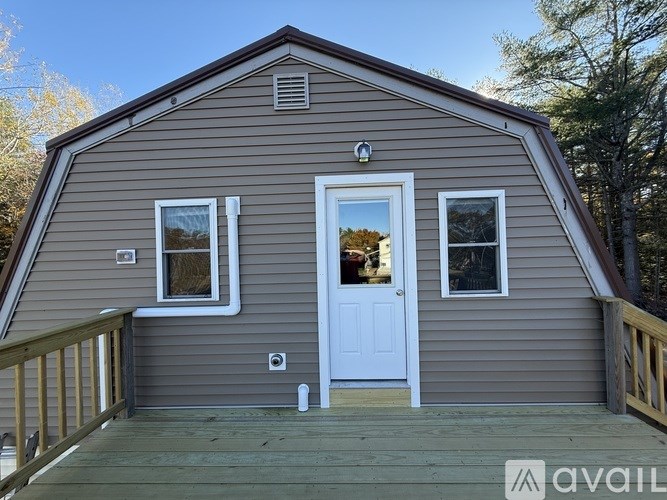 A small house with a white door and windows is available for rent.