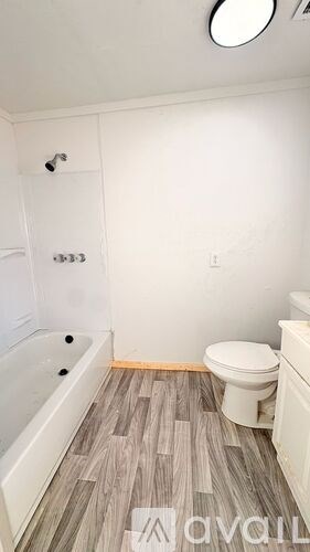 A bathroom with a tub, toilet and sink.