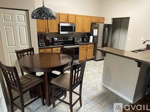 A kitchen with a table and chairs.
