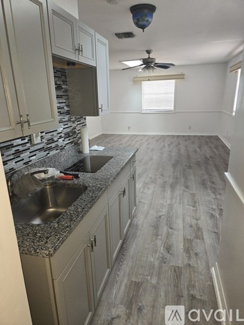 A kitchen with a sink and a fan.