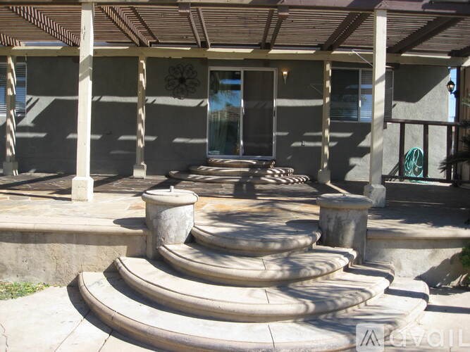 A concrete patio with steps leading to a house.
