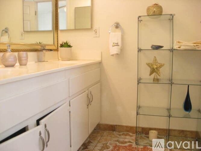 A bathroom with a white vanity and a glass shelf with a star decoration.