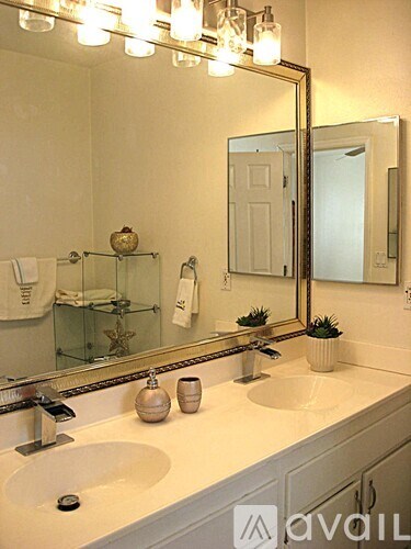 A bathroom with a large mirror above a double sink.