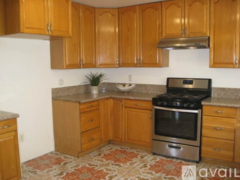 A kitchen with wooden cabinets and a black stove top oven.