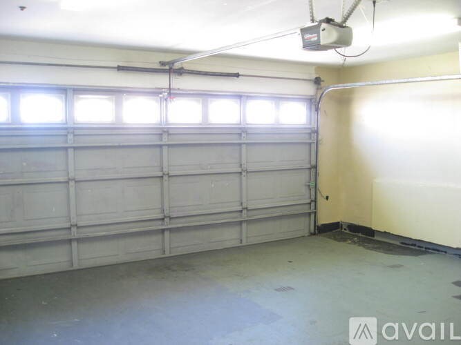 A large garage with a white door and a ceiling fan.