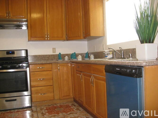 A kitchen with wooden cabinets and a stainless steel oven.