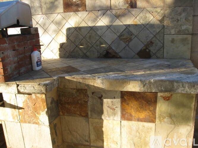 A white bottle is on a brick wall.