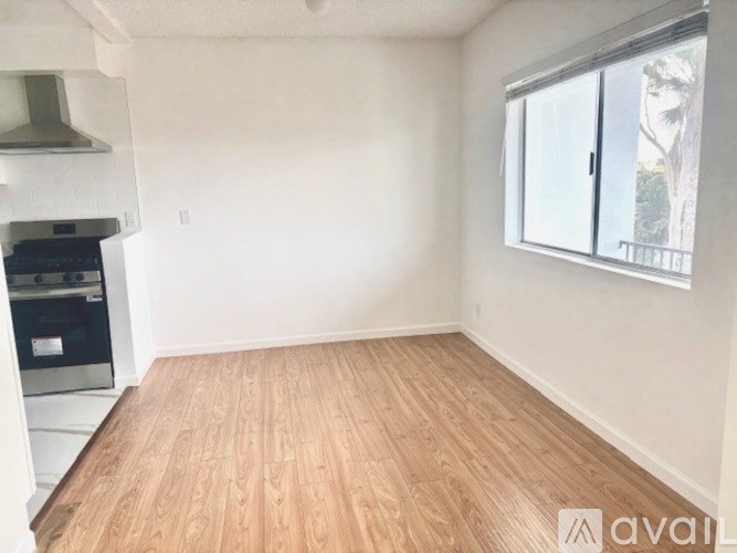A room with wooden flooring and a window with blinds.