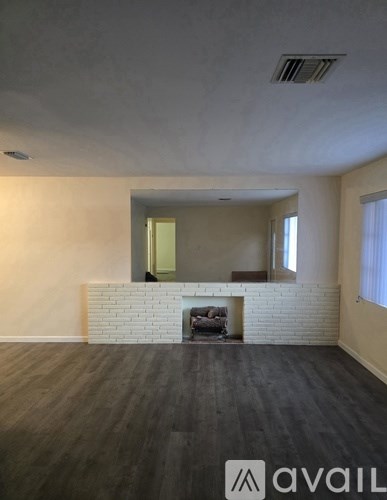 A room with a fireplace and wooden floors.