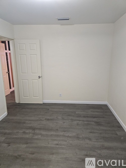 A room with a door and a grey floor.