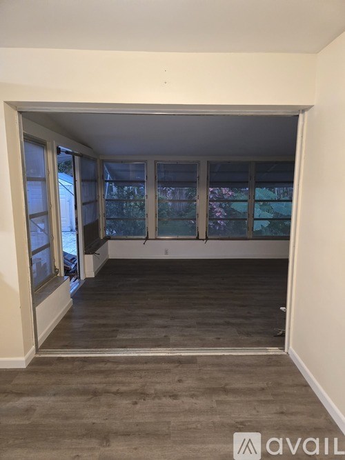 A room with a large window and a carpeted floor.