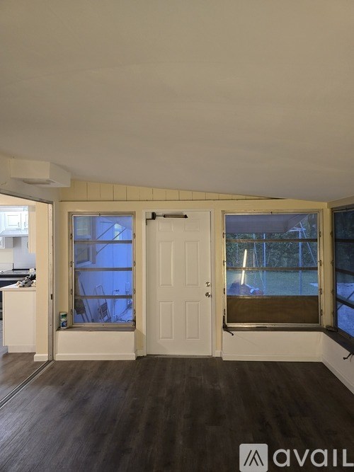 A room with a white door and a window with a view of a pool.