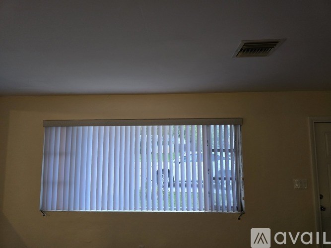 A window with blinds in a room with a ceiling fan.