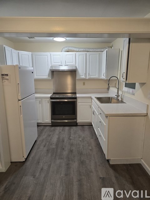 A kitchen with white cabinets and a stainless steel oven.