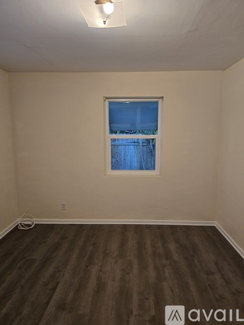 A room with a window and wooden flooring.