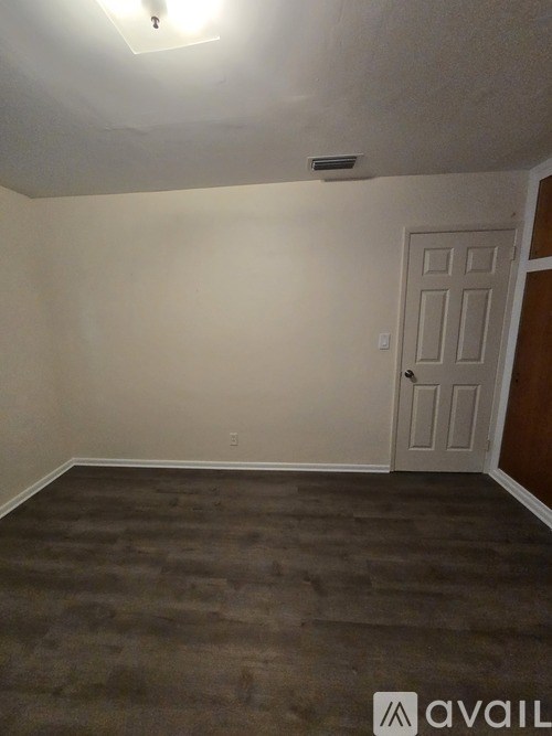 A room with a door and a carpeted floor.