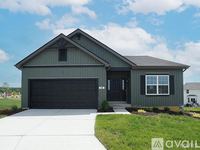 A two-story house with a garage door and a front door.