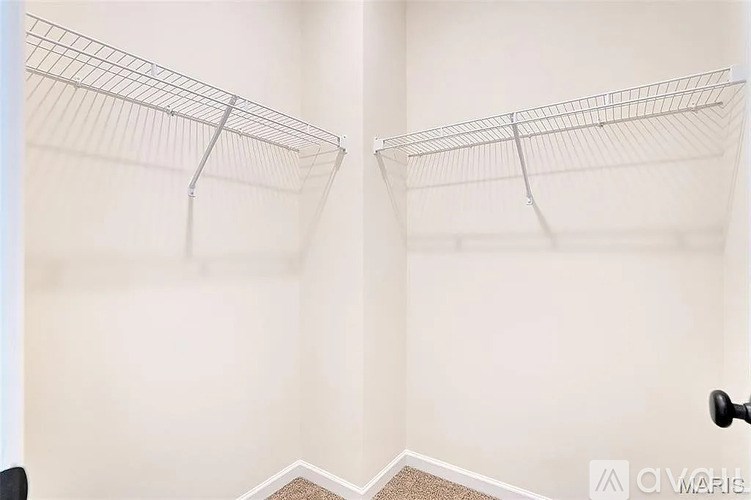 A pair of empty wire shelves are mounted on a wall.