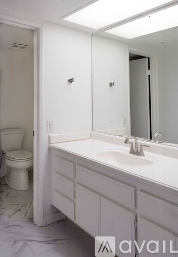 A white bathroom with a toilet and sink.