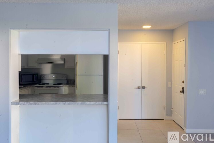 A kitchen with white cabinets and a white countertop.