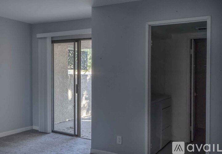 A room with a white wall and a door leading outside.