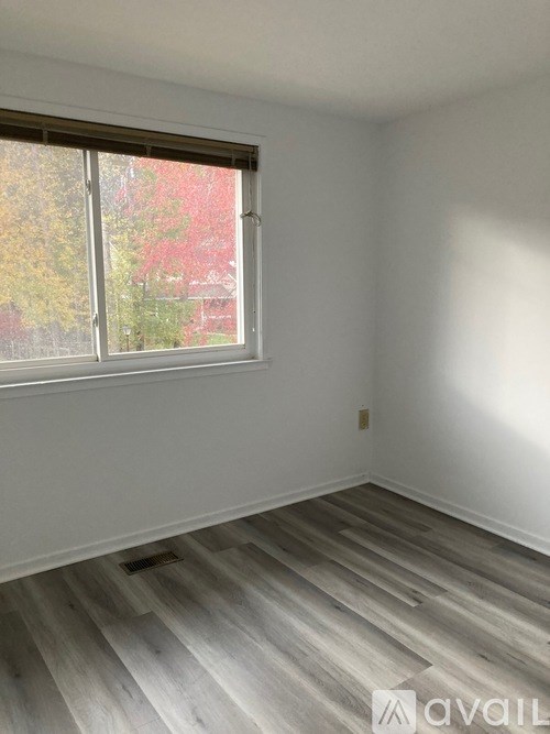 A room with a window and wooden flooring.