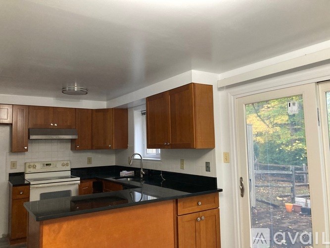 A kitchen with wooden cabinets and a black countertop.