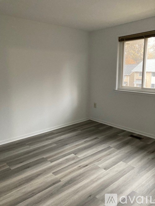A room with wooden flooring and a window.