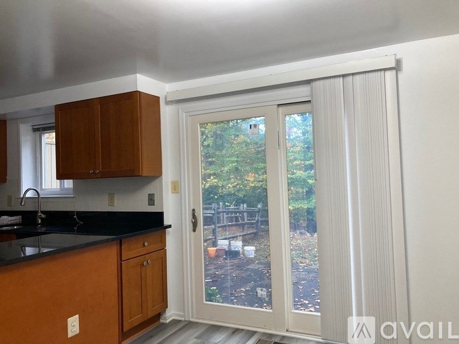 A kitchen with wooden cabinets and a black countertop.