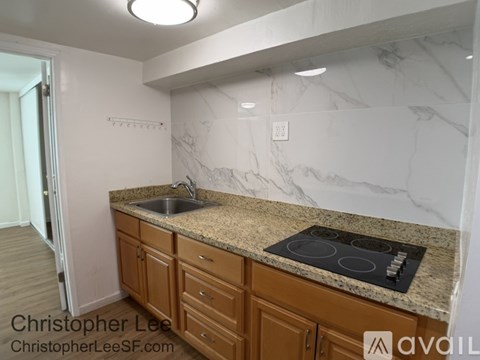 A kitchen with a marble countertop and wooden cabinets.
