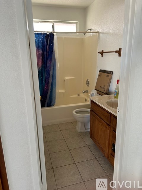 A bathroom with a toilet, sink, and shower.