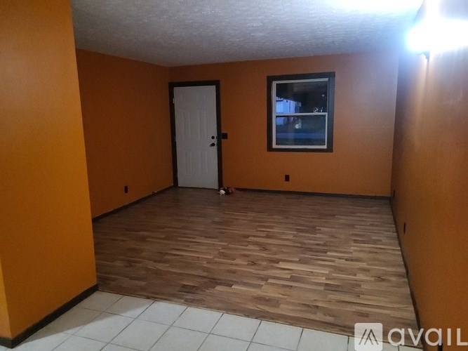 A room with orange walls and a white door.