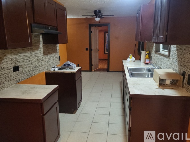 A kitchen with brown cabinets and a white countertop.