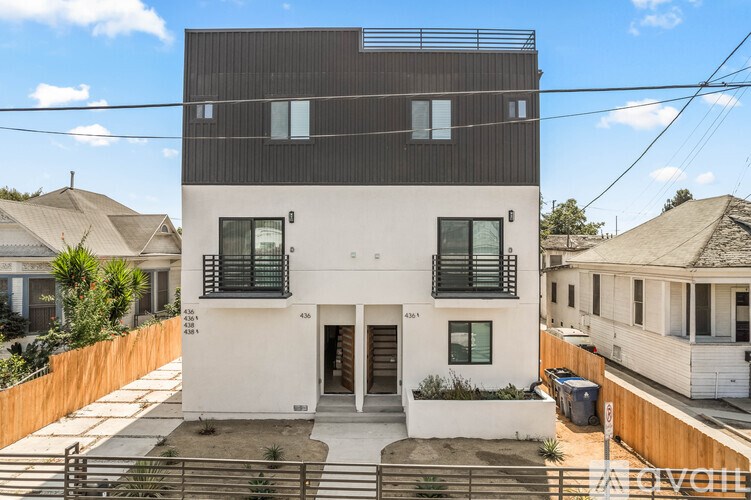 A modern two-story house with a white facade and a black upper floor.